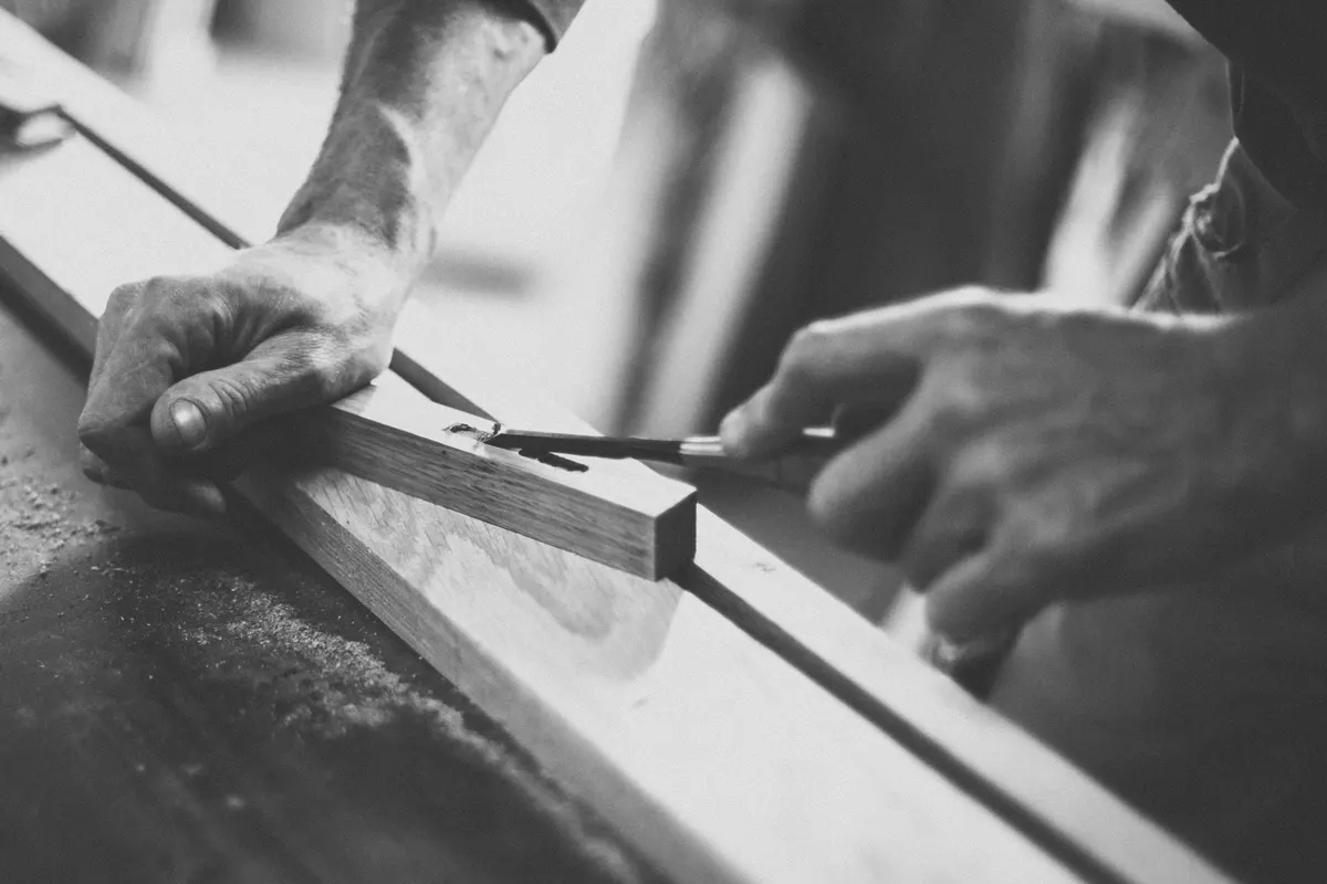 Hands working a length of oak by hand