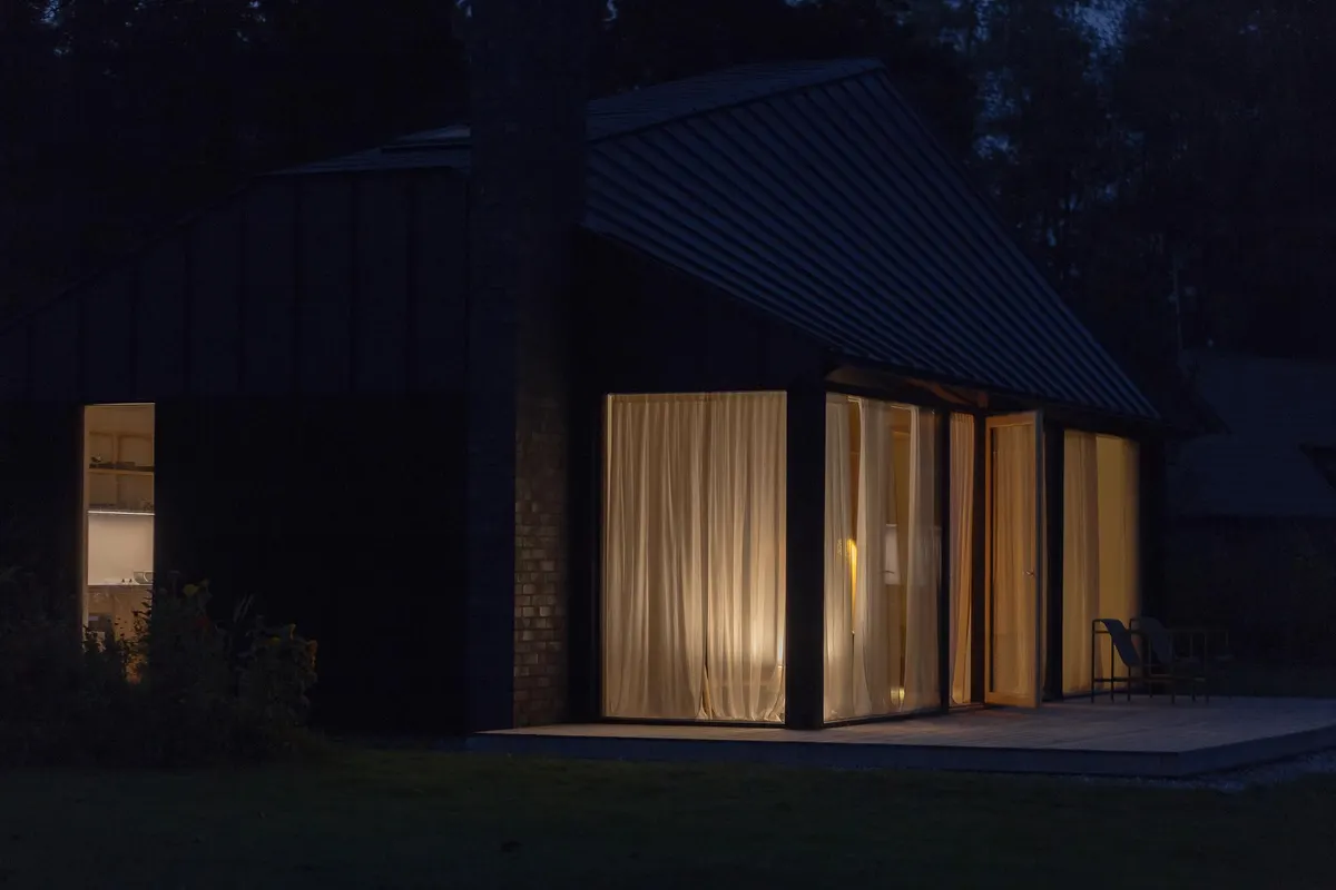 A lit house at night among trees
